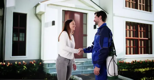 Homeowner shaking hands with pest control professional